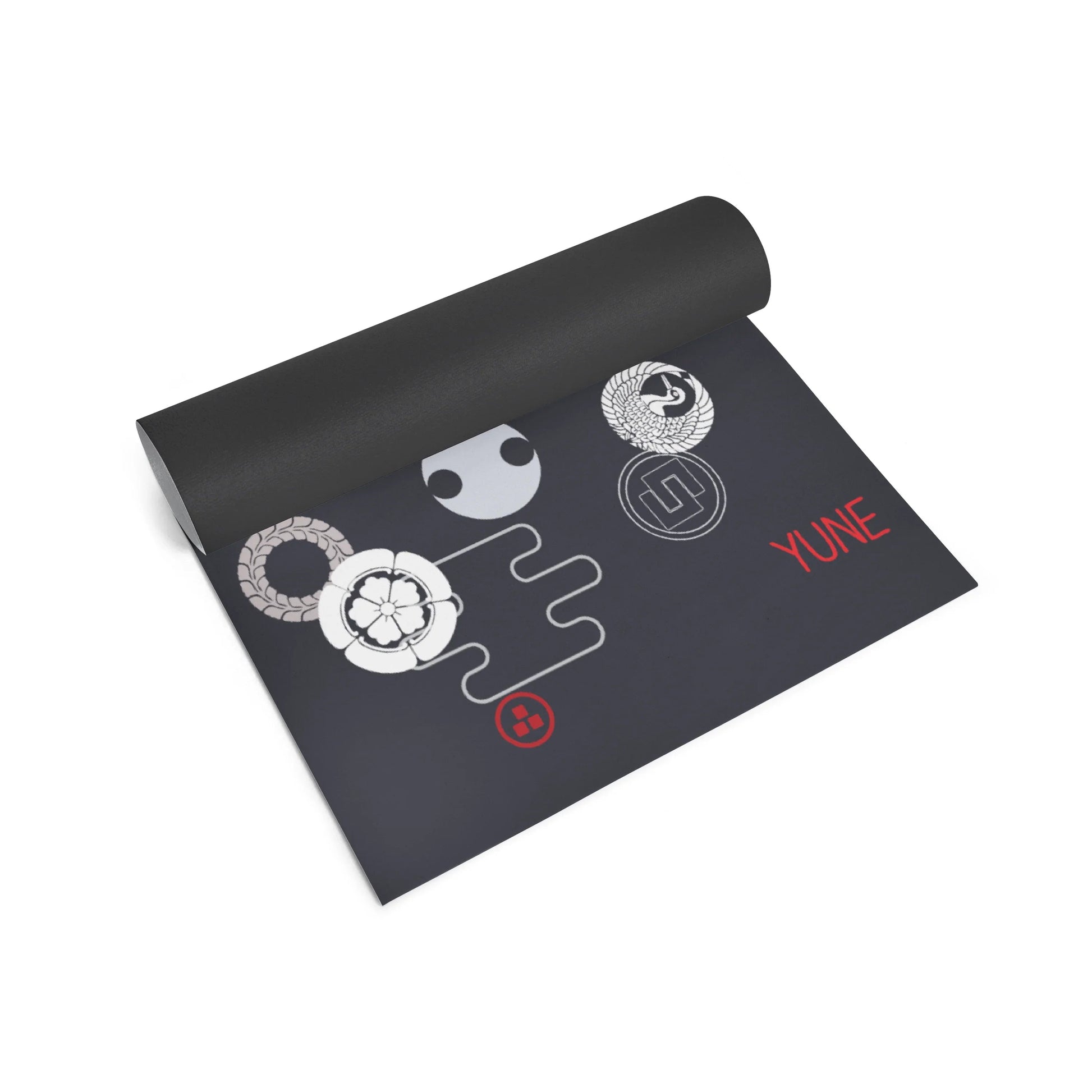 Black yoga mat with white and red designs on a white background