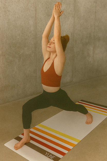 Person practicing yoga on a striped yoga mat with a neutral background