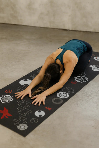 Person practicing yoga on a decorated mat with a neutral background