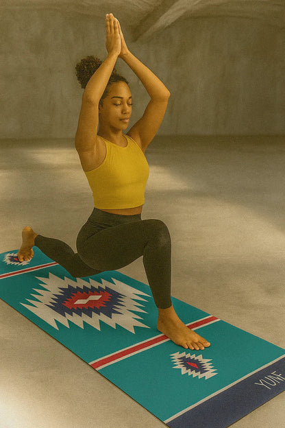Woman in a yellow top and green pants performing a yoga pose on a Yumie branded mat.