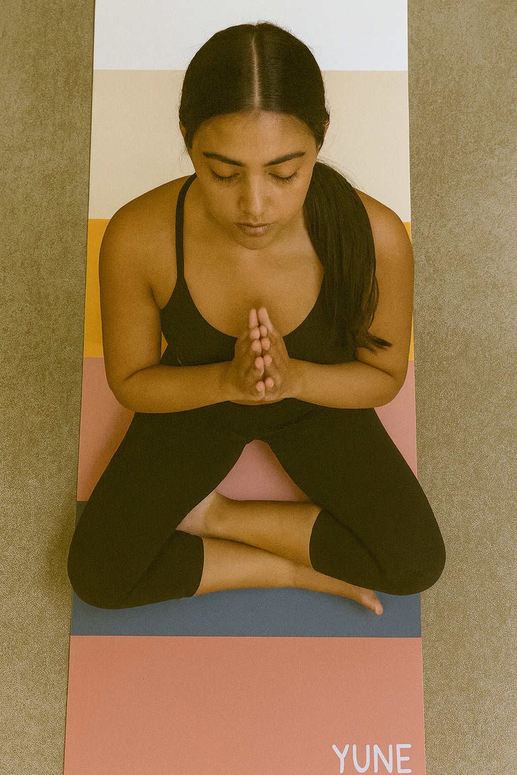Woman practicing yoga on a Yune branded mat