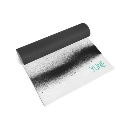 Yoga mat with black top and gradient design on a white background, featuring the brand 'YUNE'.